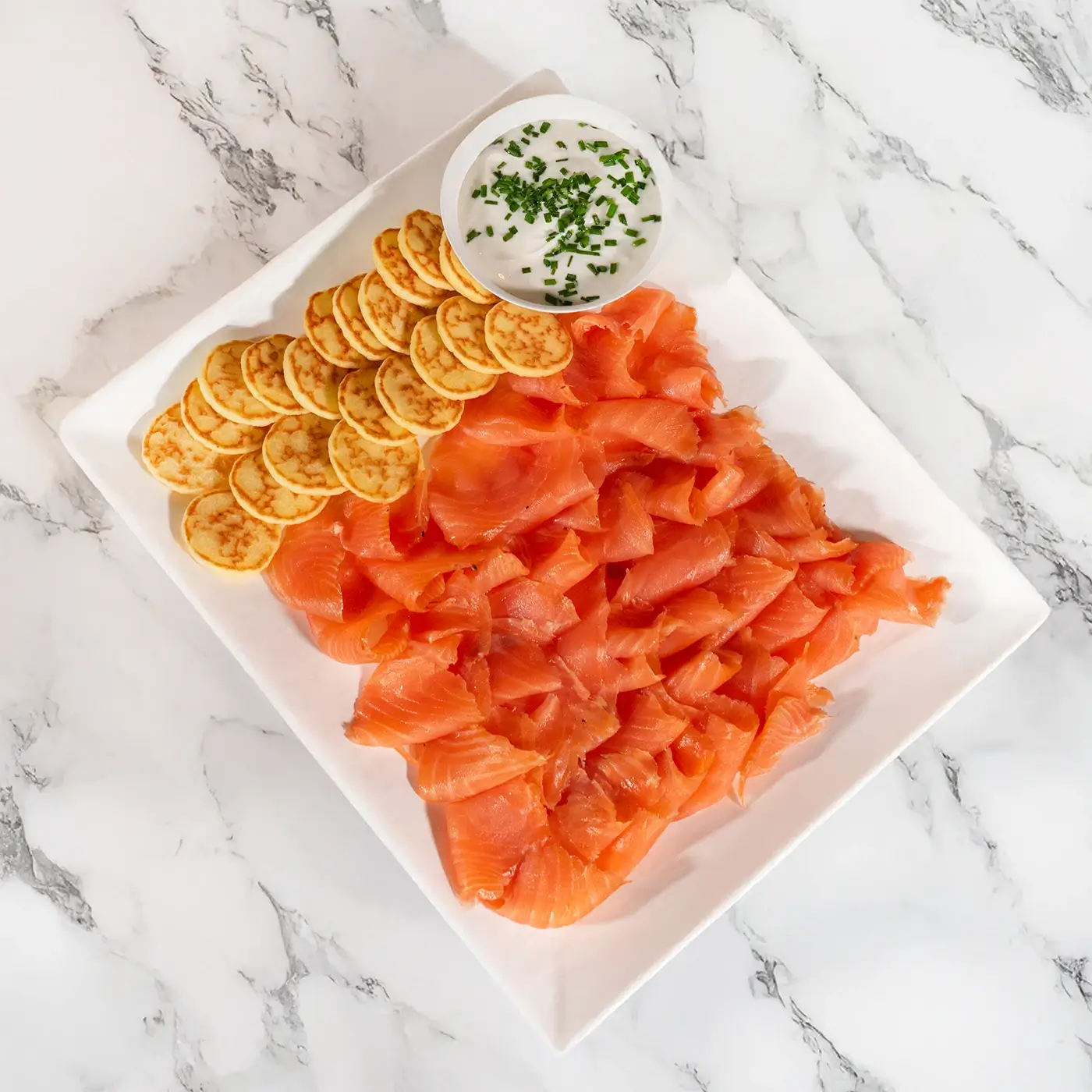 Planche de saumon fumé maison avec blinis et sauce à l’aneth