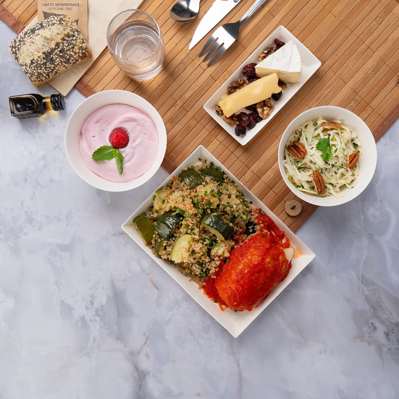 Plateau repas d'entreprise sans gluten dos de lieu noir MSC à la tomate avec courge rôtie et quinoa, servi sur set bambou avec couverts inox — Les Jardins d'Épicure, traiteur à Paris et en Île-de-France