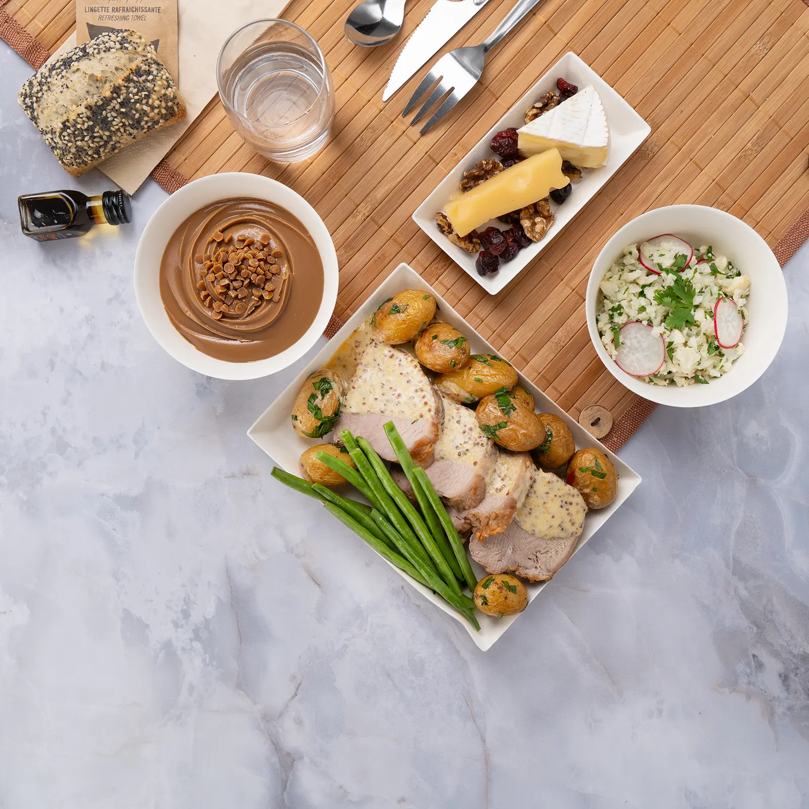 Plateau repas d'entreprise sans gluten filet mignon de porc au miel et moutarde à l'ancienne, servi sur set bambou avec couverts inox — Les Jardins d'Épicure, traiteur à Paris et en Île-de-France