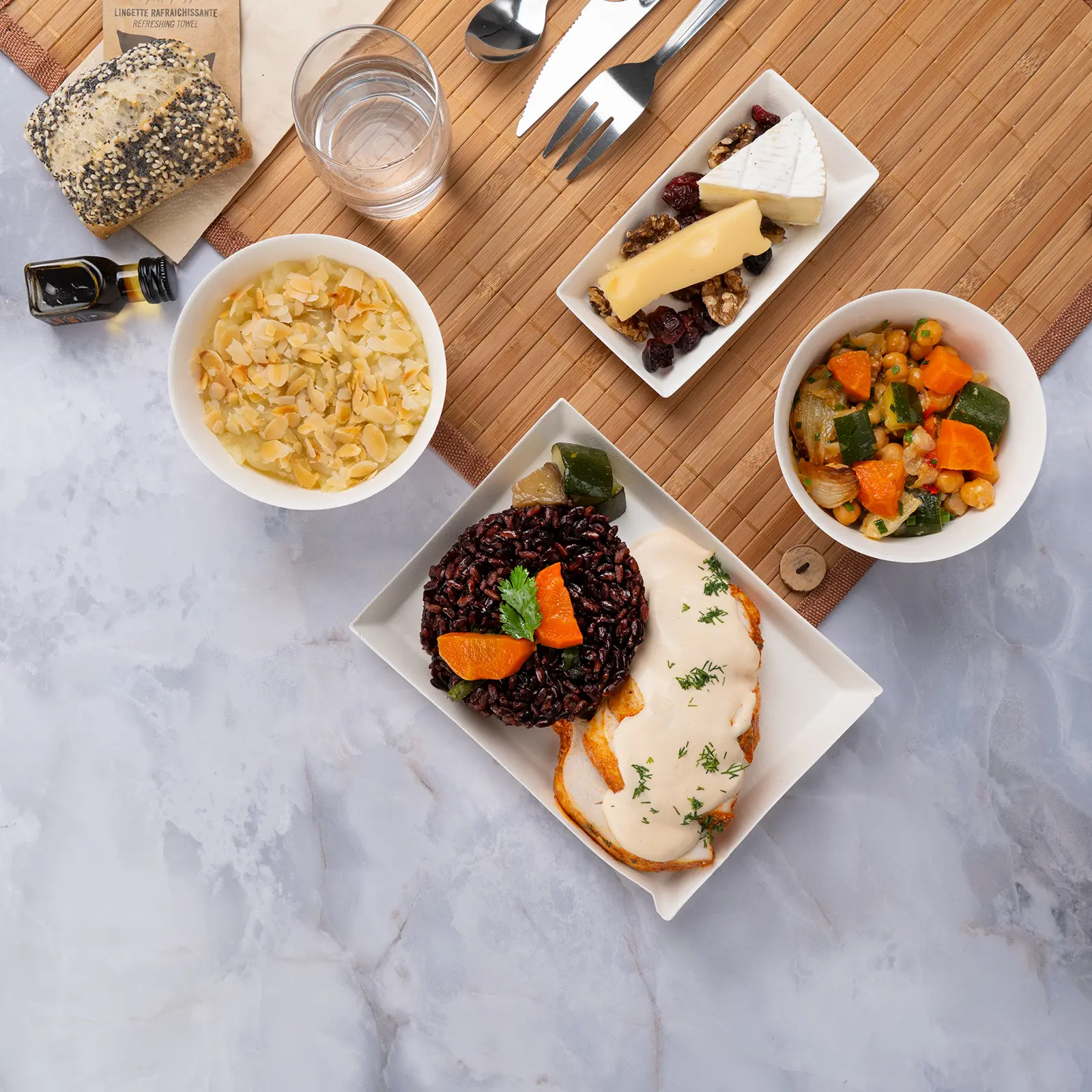 Plateau repas d'entreprise sans gluten poulet halal au citron vert, lait de coco et riz noir, servi sur set bambou avec couverts inox — Les Jardins d'Épicure, traiteur à Paris et en Île-de-France