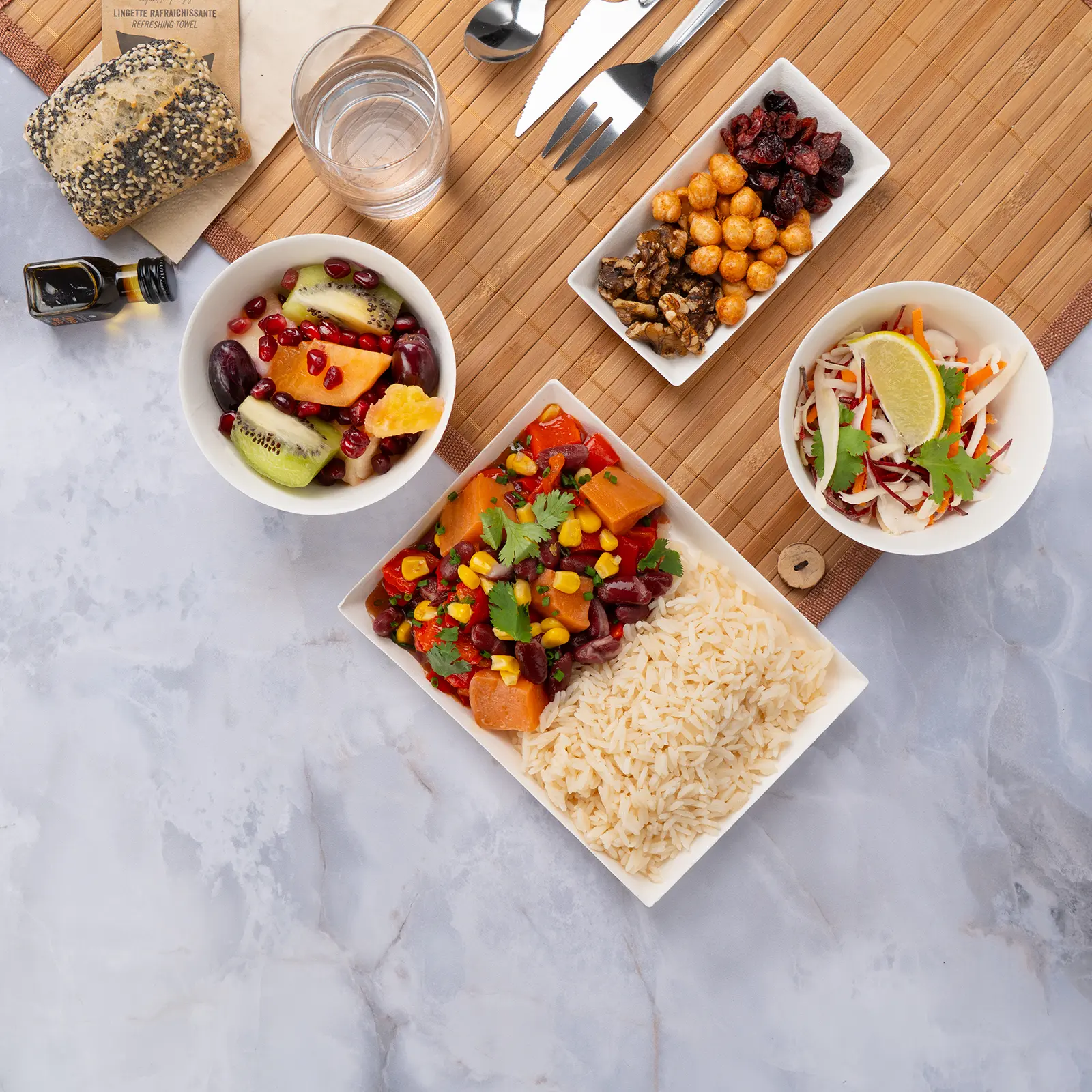 Plateau repas d'entreprise végan et sans gluten, chili sin carne aux haricots rouges et riz de Camargue, servi sur set bambou avec couverts inox — Les Jardins d'Épicure, traiteur à Paris et en Île-de-France