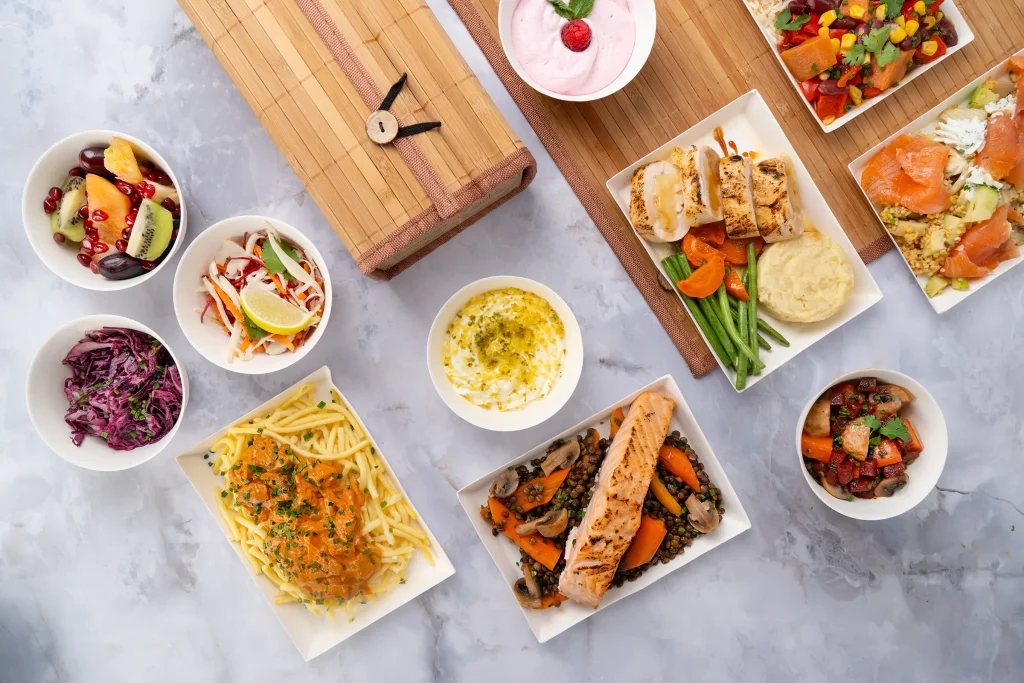 Plateaux repas d'entreprise Jardins Signature servis sur set bambou — Les Jardins d'Épicure, traiteur artisanal livrant Paris et l'Île-de-France